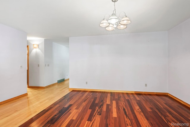 609 N Wickshire Ln, Durand, MI 48429 - spare room featuring wood finished floors and a chandelier