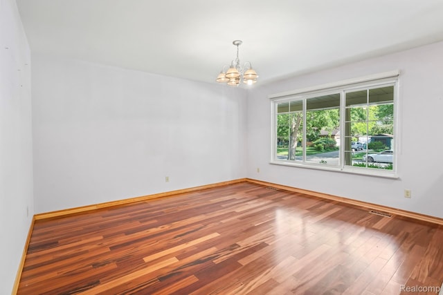 609 N Wickshire Ln, Durand, MI 48429 - spare room featuring a chandelier and wood finished floors