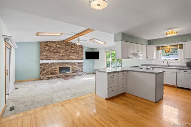 609 N Wickshire Ln, Durand, MI 48429 - kitchen with white dishwasher, light wood-type flooring, white cabinetry, and healthy amount of natural light