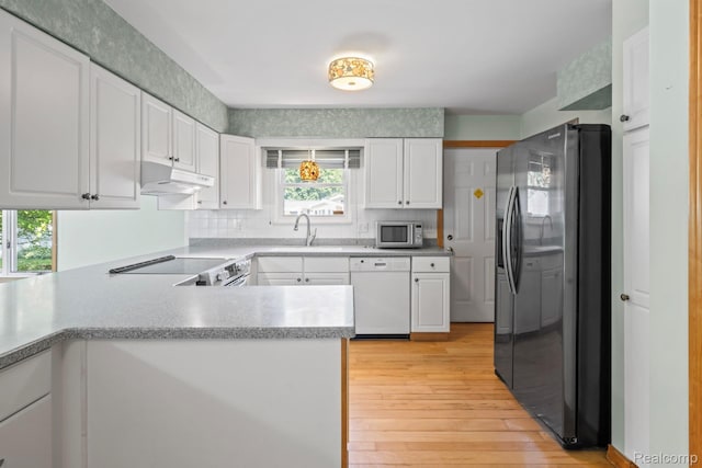 609 N Wickshire Ln, Durand, MI 48429 - kitchen with appliances with stainless steel finishes, under cabinet range hood, white cabinetry, and light wood-style floors