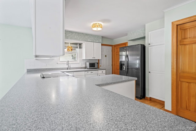 609 N Wickshire Ln, Durand, MI 48429 - kitchen featuring stainless steel appliances, white cabinetry, a peninsula, backsplash, and light countertops