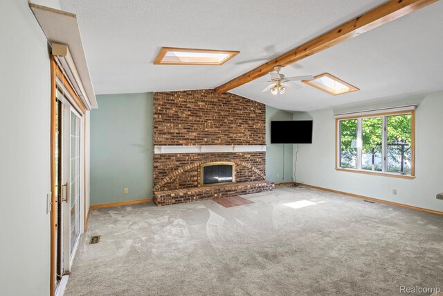609 N Wickshire Ln, Durand, MI 48429 - unfurnished living room featuring a skylight, carpet flooring, a fireplace, and ceiling fan