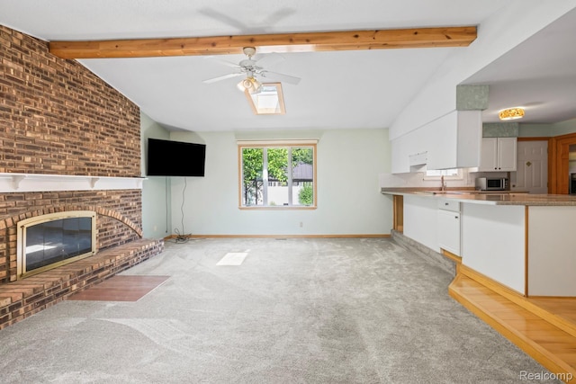 609 N Wickshire Ln, Durand, MI 48429 - unfurnished living room with ceiling fan, light colored carpet, and a fireplace
