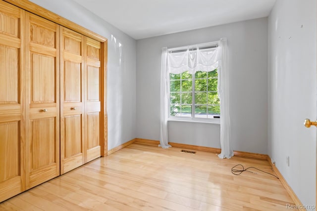 609 N Wickshire Ln, Durand, MI 48429 - unfurnished bedroom with light wood-style floors and a closet