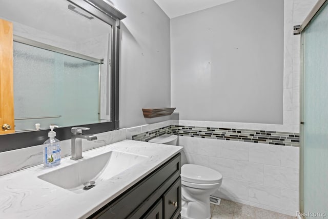 609 N Wickshire Ln, Durand, MI 48429 - bathroom with tile walls, vanity, tile patterned floors, a shower stall, and a wainscoted wall
