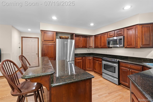 260 Forest Crest Dr, Commerce Twp, MI 48390 - kitchen with appliances with stainless steel finishes, light wood-style floors, a kitchen breakfast bar, a kitchen island, and recessed lighting