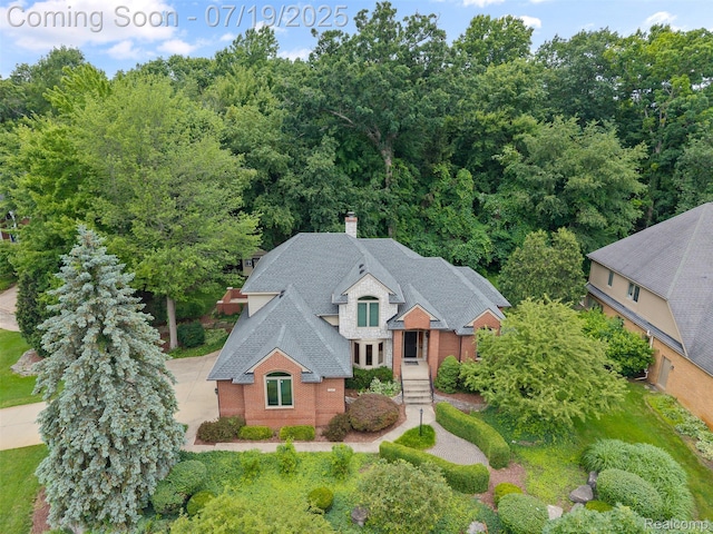 260 Forest Crest Dr, Commerce Twp, MI 48390 - view of front of property with a chimney, brick siding, and a shingled roof