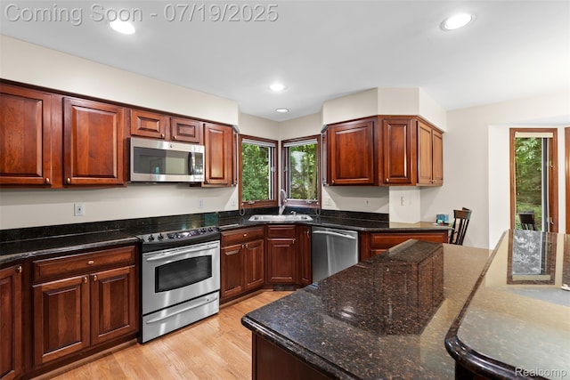 260 Forest Crest Dr, Commerce Twp, MI 48390 - kitchen featuring appliances with stainless steel finishes, light wood-style flooring, dark stone counters, and recessed lighting