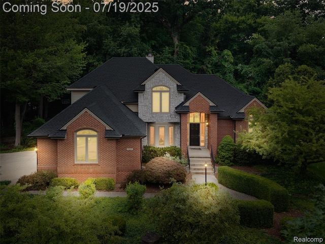 260 Forest Crest Dr, Commerce Twp, MI 48390 - view of front facade with roof with shingles, stone siding, a chimney, and brick siding