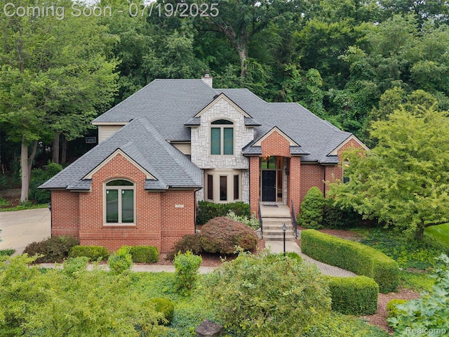 260 Forest Crest Dr, Commerce Twp, MI 48390 - french country inspired facade with roof with shingles, stone siding, a chimney, and brick siding