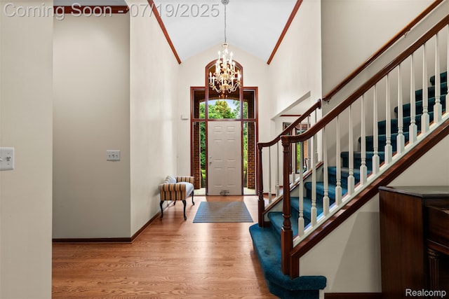 260 Forest Crest Dr, Commerce Twp, MI 48390 - foyer entrance with stairs, wood finished floors, a chandelier, and high vaulted ceiling