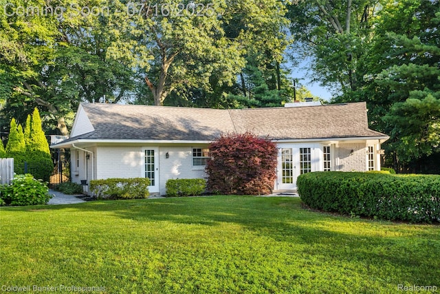 56 Oxford Rd, Grosse Pointe Shores, MI 48236 - view of front of property with brick siding, a front lawn, french doors, and a shingled roof