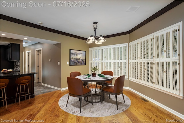 56 Oxford Rd, Grosse Pointe Shores, MI 48236 - dining room featuring light wood-type flooring, bar area, a chandelier, ornamental molding, and recessed lighting