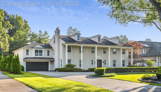 56 Oxford Rd, Grosse Pointe Shores, MI 48236 - view of front facade with a chimney, a garage, driveway, and a front yard