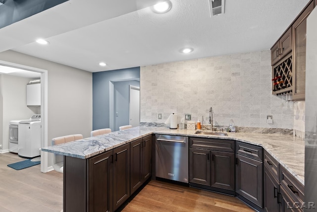 579 Budlong St, Adrian, MI 49221 - kitchen featuring dishwasher, separate washer and dryer, light wood-style flooring, decorative backsplash, and recessed lighting