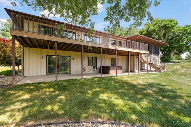 579 Budlong St, Adrian, MI 49221 - back of property with a hot tub, a patio area, a deck, a lawn, and stairs