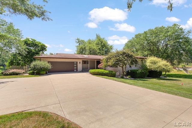 579 Budlong St, Adrian, MI 49221 - ranch-style house featuring driveway, an attached garage, and a front lawn