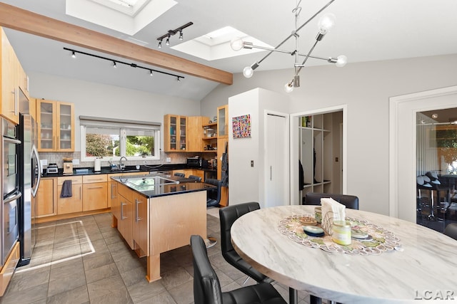 579 Budlong St, Adrian, MI 49221 - kitchen featuring a kitchen island, track lighting, a skylight, and backsplash