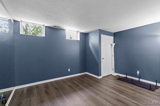 579 Budlong St, Adrian, MI 49221 - below grade area featuring wood finished floors and a textured ceiling