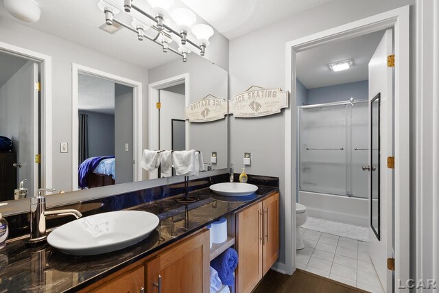 579 Budlong St, Adrian, MI 49221 - bathroom featuring double vanity, shower / bath combination with glass door, and ensuite bath