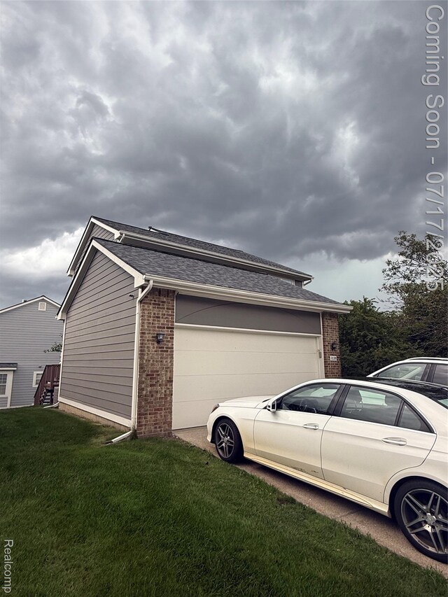 31199 Columbia Dr, Novi, MI 48377 - view of side of property with brick siding, a yard, a shingled roof, and an attached garage