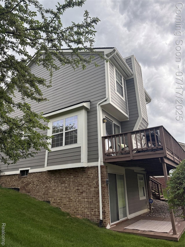 31199 Columbia Dr, Novi, MI 48377 - rear view of house featuring brick siding, a wooden deck, a chimney, and a yard