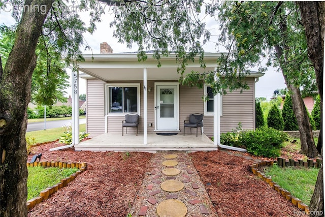 5758 N Parent St, Westland, MI 48185 - back of house with covered porch and a chimney