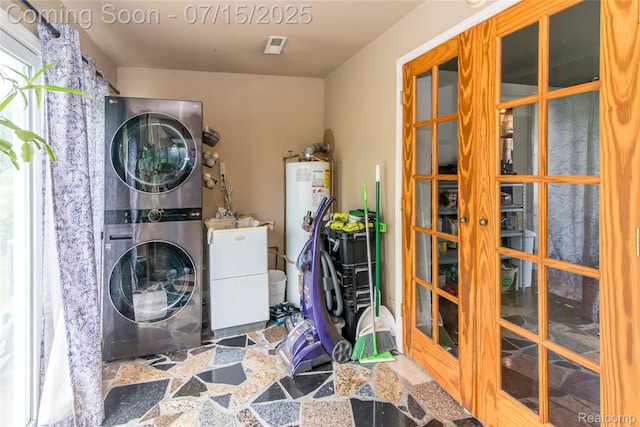 5758 N Parent St, Westland, MI 48185 - laundry room with stacked washer / drying machine, stone finish floors, french doors, and water heater