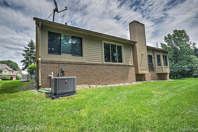 7071 Deerwood Trl Unit 28, West Bloomfield, MI 48323 - view of side of home featuring brick siding, a yard, and a chimney