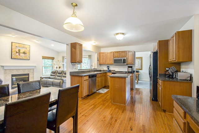 7269 Wellington Ln, Ypsilanti, MI 48197 - kitchen with stainless steel appliances, dark countertops, a kitchen island, hardwood / wood-style flooring, and lofted ceiling