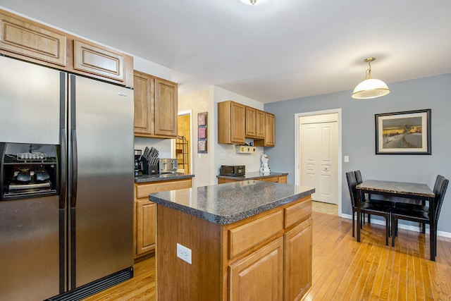 7269 Wellington Ln, Ypsilanti, MI 48197 - kitchen with stainless steel refrigerator with ice dispenser, light wood-type flooring, dark countertops, a kitchen island, and brown cabinets