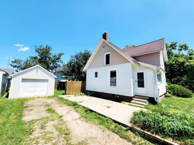 214 S Gorham St, Jackson, MI 49203 - view of side of home with a chimney, driveway, entry steps, a garage, and an outbuilding