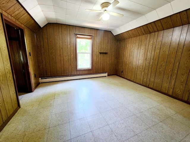 214 S Gorham St, Jackson, MI 49203 - spare room featuring a baseboard heating unit, a ceiling fan, light flooring, vaulted ceiling, and wood walls
