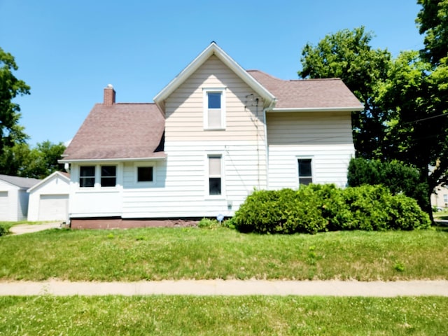 214 S Gorham St, Jackson, MI 49203 - view of side of property featuring a chimney, a lawn, and a garage