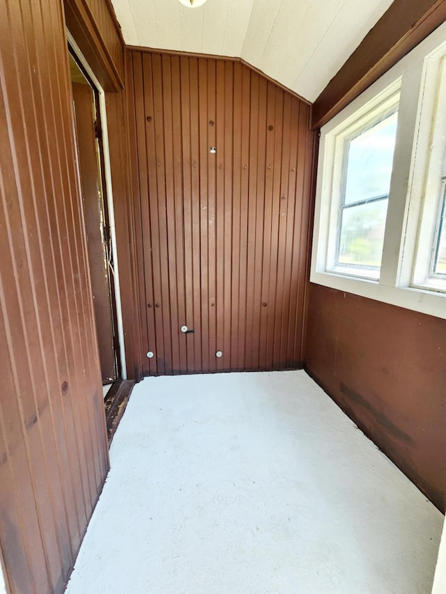 214 S Gorham St, Jackson, MI 49203 - carpeted empty room with wood walls and vaulted ceiling