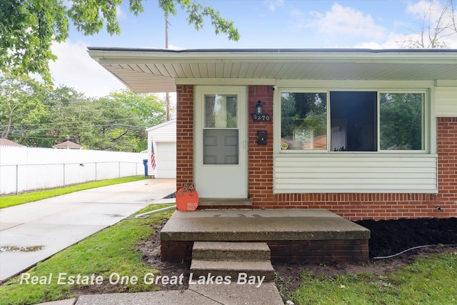 2270 Anderson Rd, Saginaw, MI 48603 - view of exterior entry featuring driveway, brick siding, and a garage