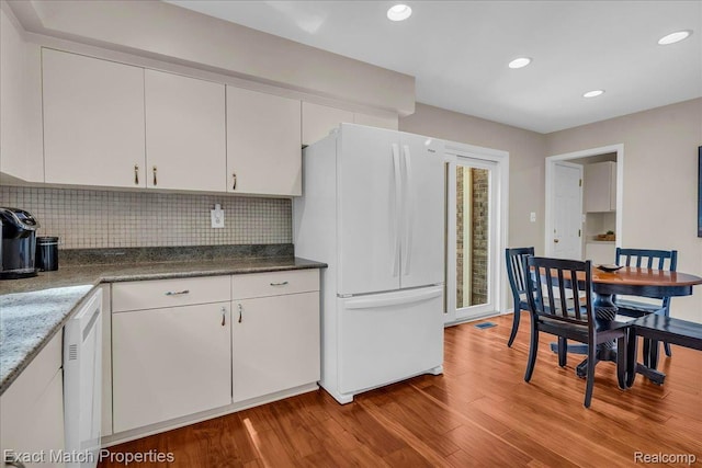 3742 Hearthstone Dr, Commerce Twp, MI 48382 - kitchen with freestanding refrigerator, white cabinetry, wood finished floors, decorative backsplash, and dishwasher