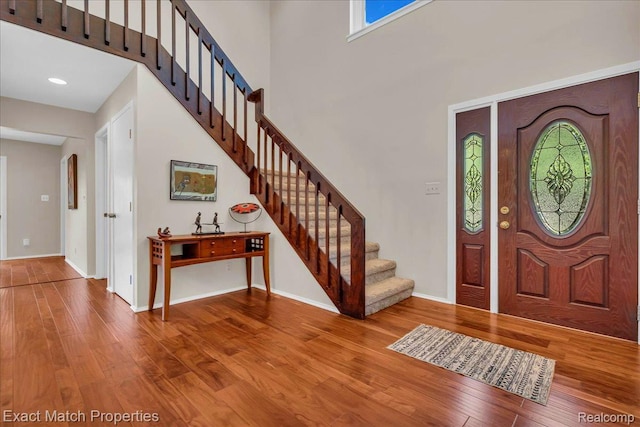 3742 Hearthstone Dr, Commerce Twp, MI 48382 - foyer entrance featuring stairs, wood finished floors, and a towering ceiling