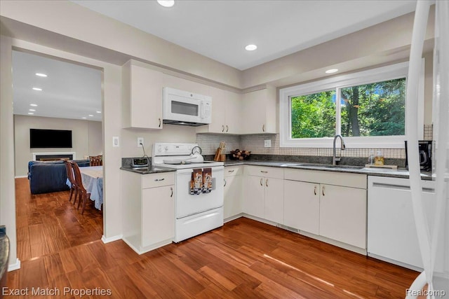 3742 Hearthstone Dr, Commerce Twp, MI 48382 - kitchen featuring white appliances, wood finished floors, dark countertops, white cabinetry, and decorative backsplash
