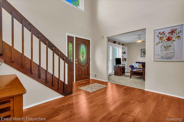 3742 Hearthstone Dr, Commerce Twp, MI 48382 - foyer with wood finished floors, stairs, a ceiling fan, and a high ceiling