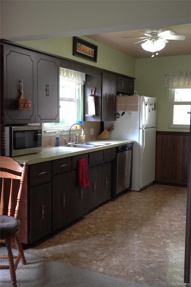 1295 Hadley Rd, Lapeer, MI 48446 - kitchen with stainless steel appliances, wainscoting, light countertops, a ceiling fan, and light floors
