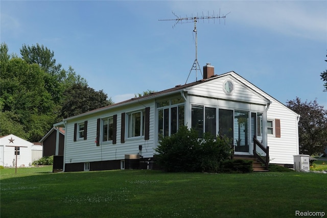 1295 Hadley Rd, Lapeer, MI 48446 - view of front of home with a shed, a chimney, a front lawn, a sunroom, and entry steps