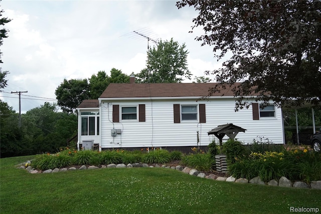 1295 Hadley Rd, Lapeer, MI 48446 - back of house with a yard, a chimney, and a sunroom