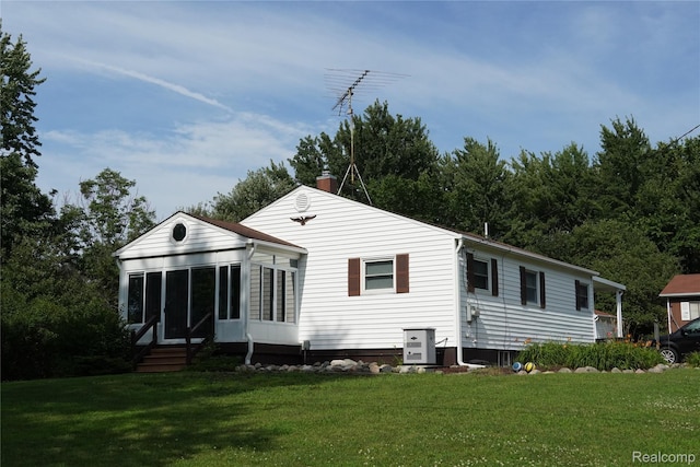 1295 Hadley Rd, Lapeer, MI 48446 - back of house featuring entry steps, a lawn, a chimney, and a sunroom