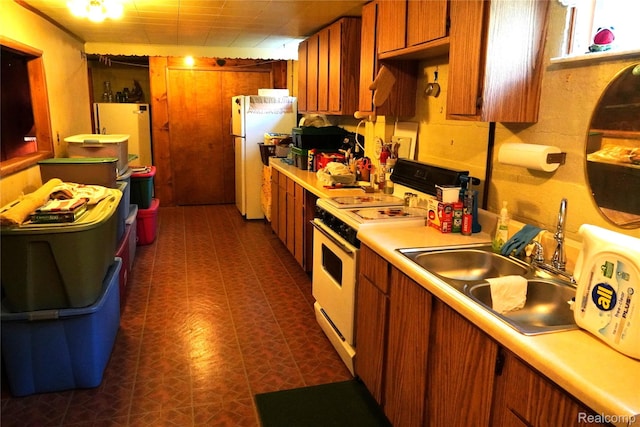 1295 Hadley Rd, Lapeer, MI 48446 - kitchen with white appliances, light countertops, brown cabinetry, and dark flooring