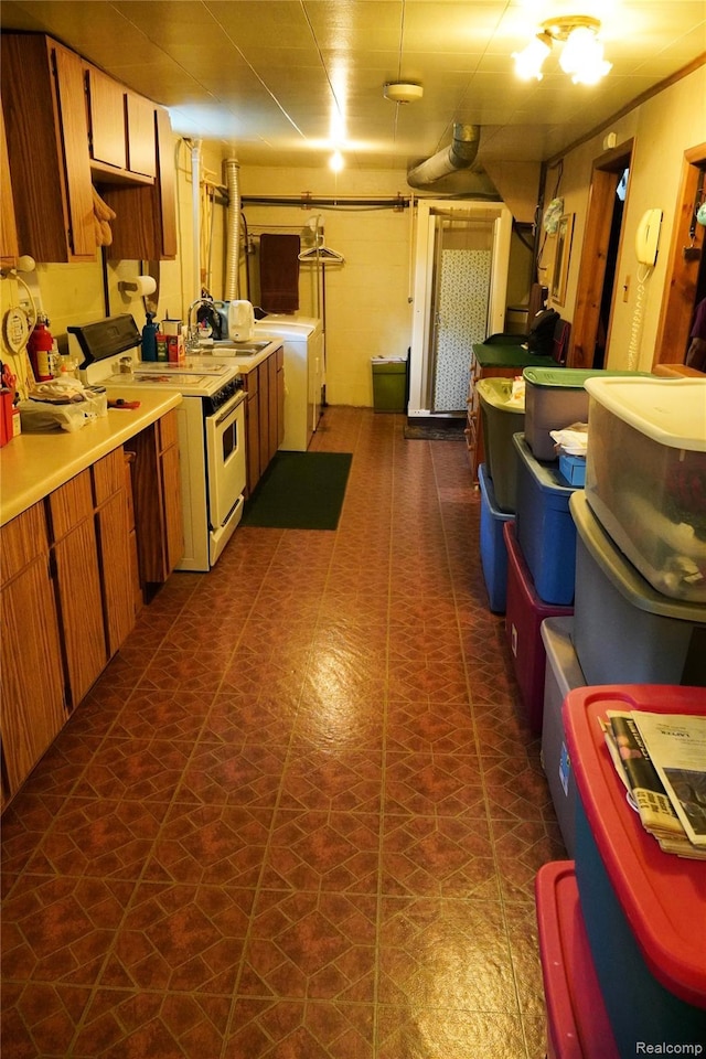 1295 Hadley Rd, Lapeer, MI 48446 - kitchen with white range with electric stovetop, washer / dryer, light countertops, and brown cabinets