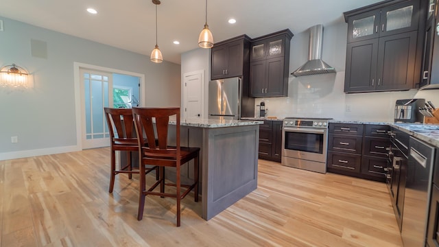 2816 Niles Buchanan Rd, Buchanan, MI 49107 - kitchen with appliances with stainless steel finishes, wall chimney range hood, a center island, light wood finished floors, and recessed lighting