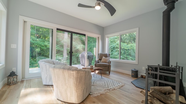 2816 Niles Buchanan Rd, Buchanan, MI 49107 - living room featuring a wood stove, ceiling fan, plenty of natural light, and wood finished floors