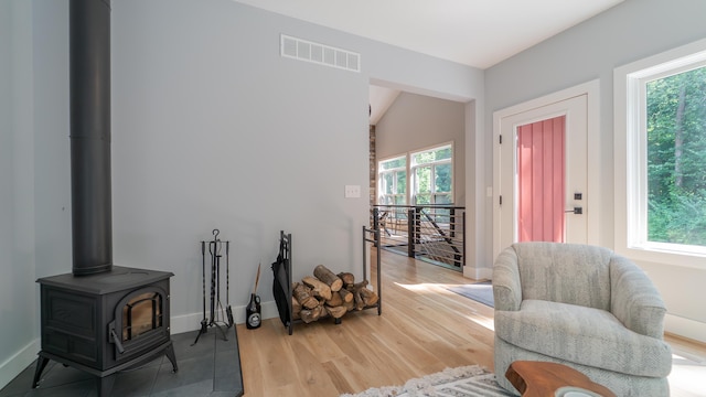 2816 Niles Buchanan Rd, Buchanan, MI 49107 - sitting room with an upstairs landing, a wood stove, light wood-style floors, and lofted ceiling