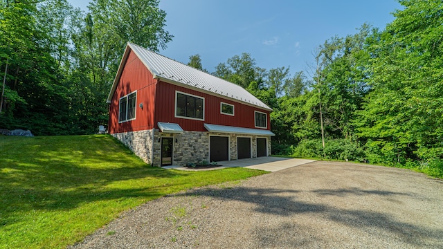 2816 Niles Buchanan Rd, Buchanan, MI 49107 - view of side of property with stone siding, gravel driveway, a metal roof, a yard, and an attached garage